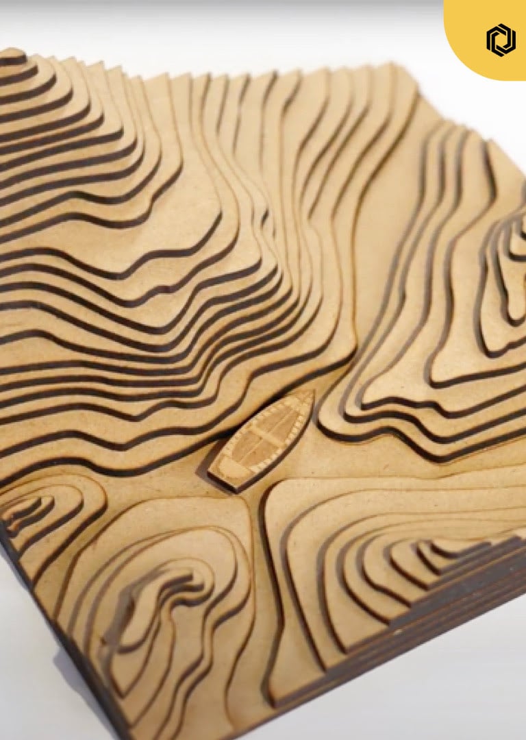 Topographic view with several laser cut layers creating mountains and a small vessel in MDF.