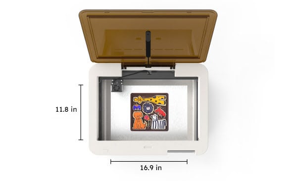 Top down view of an open FLUX Ador machine. It contains a colorful wooden puzzle with animals. The measurements are marked alongside the machine. 430 mm wide and 300 mm depth