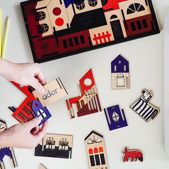 A bunch of color printed designes that are being assembled into a city in 3D.