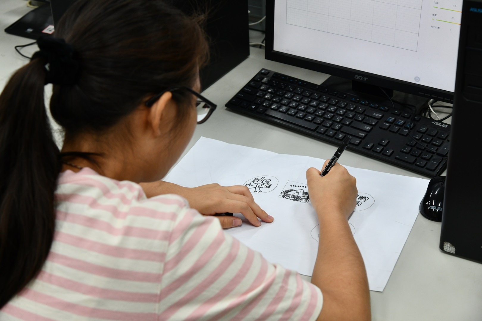 A student drawing a design on paper