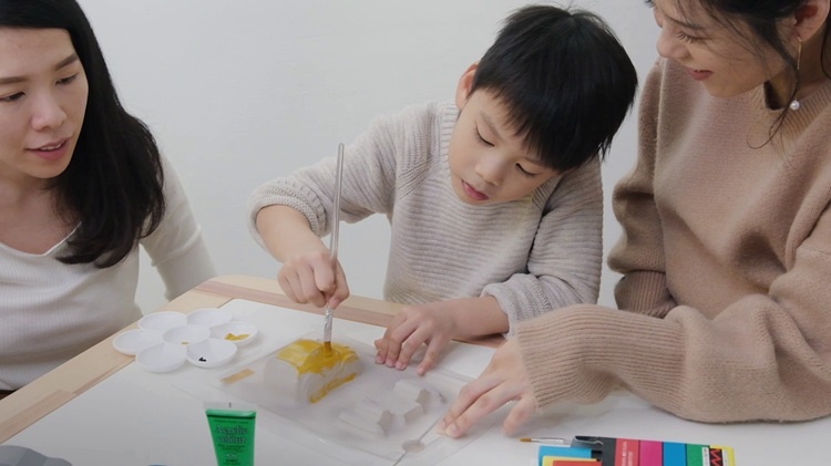 A child painting a model car that was molded with a vacuum former