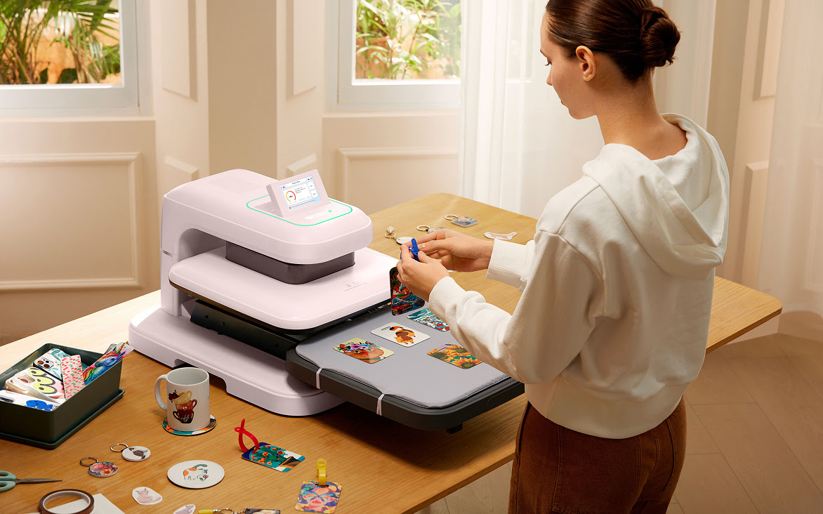 LOKLiK ImPress™ Auto 2-Smart in Daisy White on a wooden table. A woman is heat pressing a deseign on a sweater.