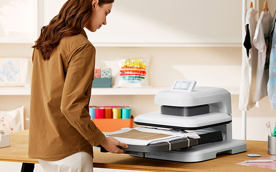 LOKLiK ImPress™ Auto 2-Smart in Daisy White on a wooden table. A woman is pulling out the ironing board which has a white T-shirt and teflon sheet lying on top.