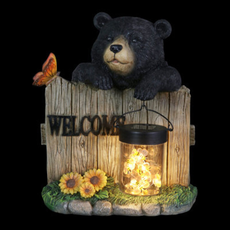 Exhart Solar Hand Painted Bear Garden Statue with a Lantern Jar of LED Bumblebees by a Welcome Fence