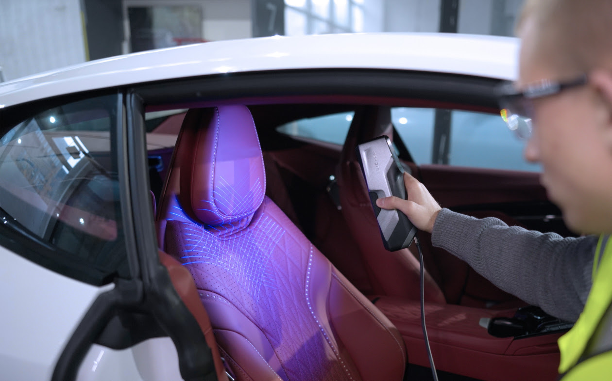 Person using the 3DeVOK blue laser mode to scan the seat of a car
