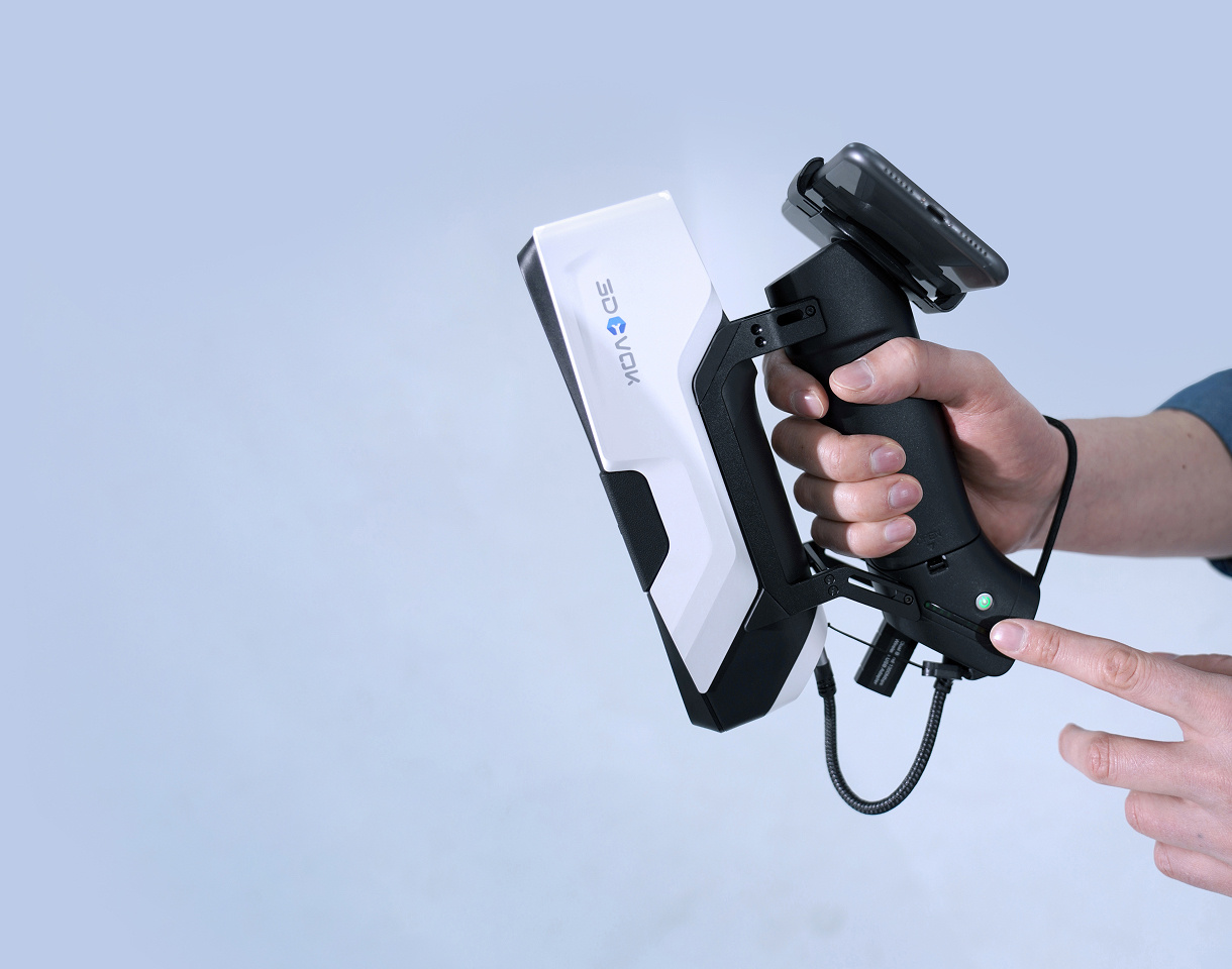 Hand holding the 3DeVOK MQ with the wireless handle. The other hand is pointing at a green led light on the handle.
