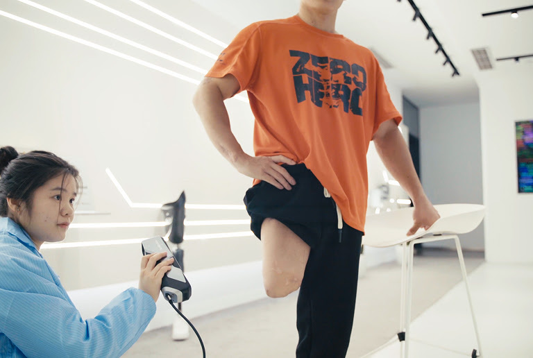 Woman scanning part of a man with an amputated leg.