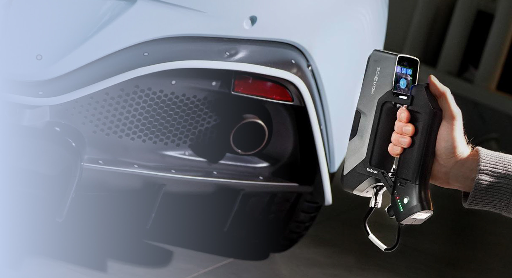 Hand holding the 3DeVOK MT Gen2 with the Airgo Wireless handle, 3D scanning the back bumper of a light blue car without markers.