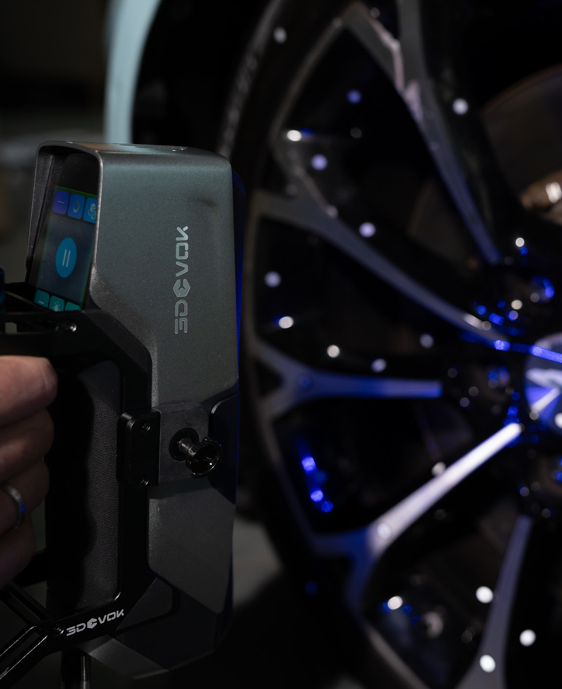 Hand holding the 3DeVOK MT Gen2 with the Airgo Wireless handle, 3D scanning the hub of a car wheel without markers.
