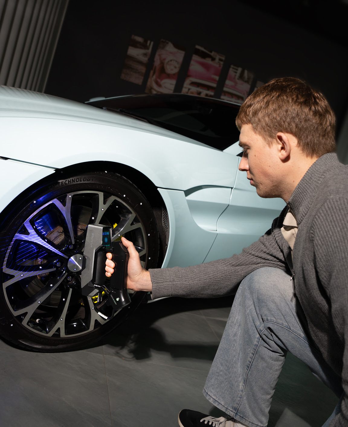Person holding the 3DeVOK MT Gen2 with the Airgo Wireless handle, 3D scanning the wheel of a car without markers.