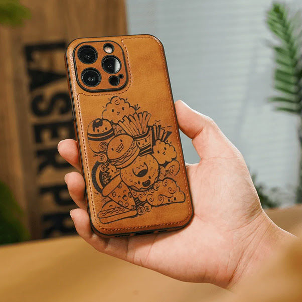 Hand holding a leather phone case cover with a laser engraved design of illustrations of cute food like fries, hamburger, pizza, donut,...
