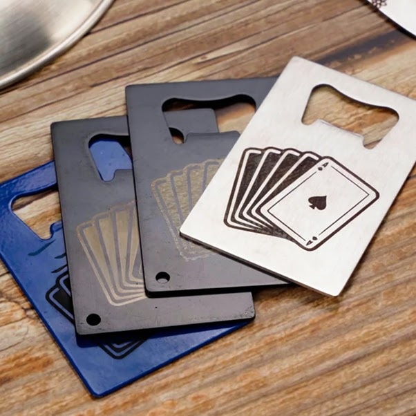 Rectangular metal can openers with an engraved design of a 4 playing cards, the ace of spades showing.