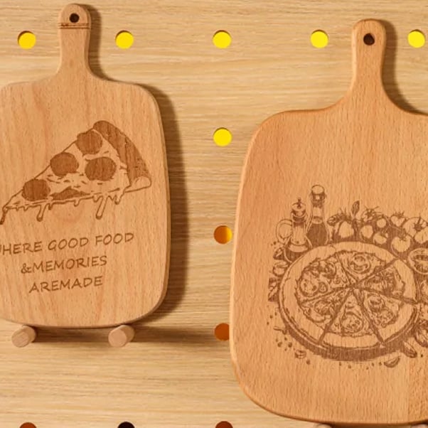 Two cutting boards with laser engraved designs of a slice of pizza and a whole pizza.