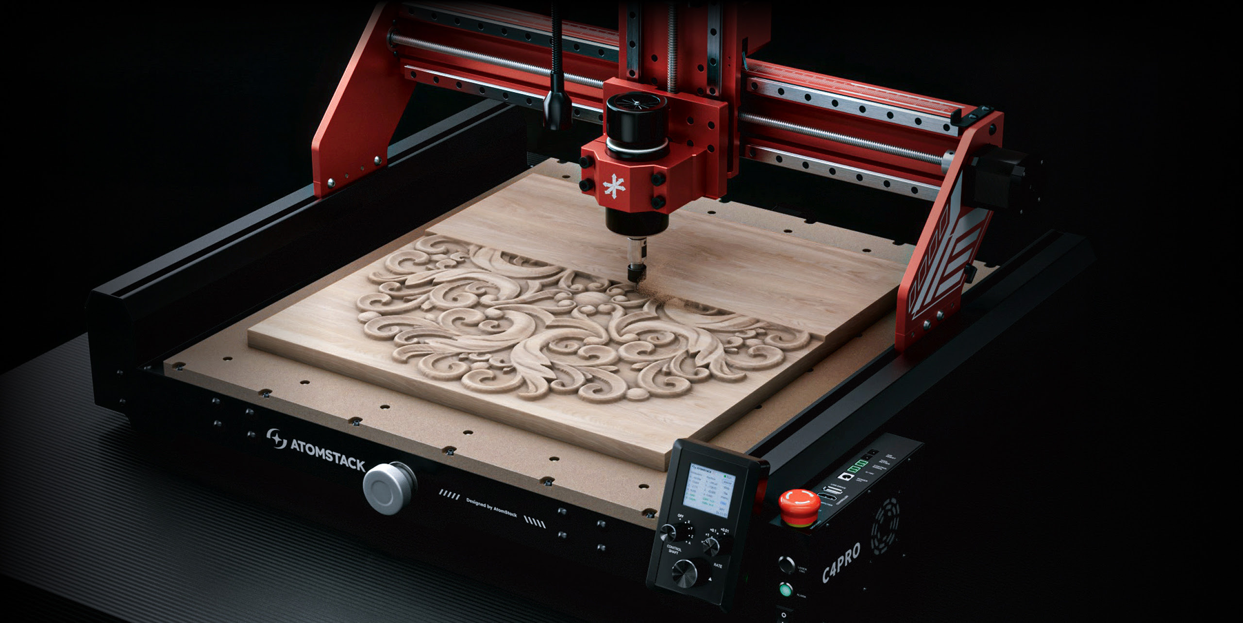 AtomStack C4 CNC router seen at an angle. A piece of wood is being milled revealing an intricate pattern of swirls.