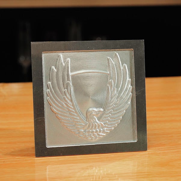 Square picture frame with a piece of aluminum with a milled eagled spreading its wings.