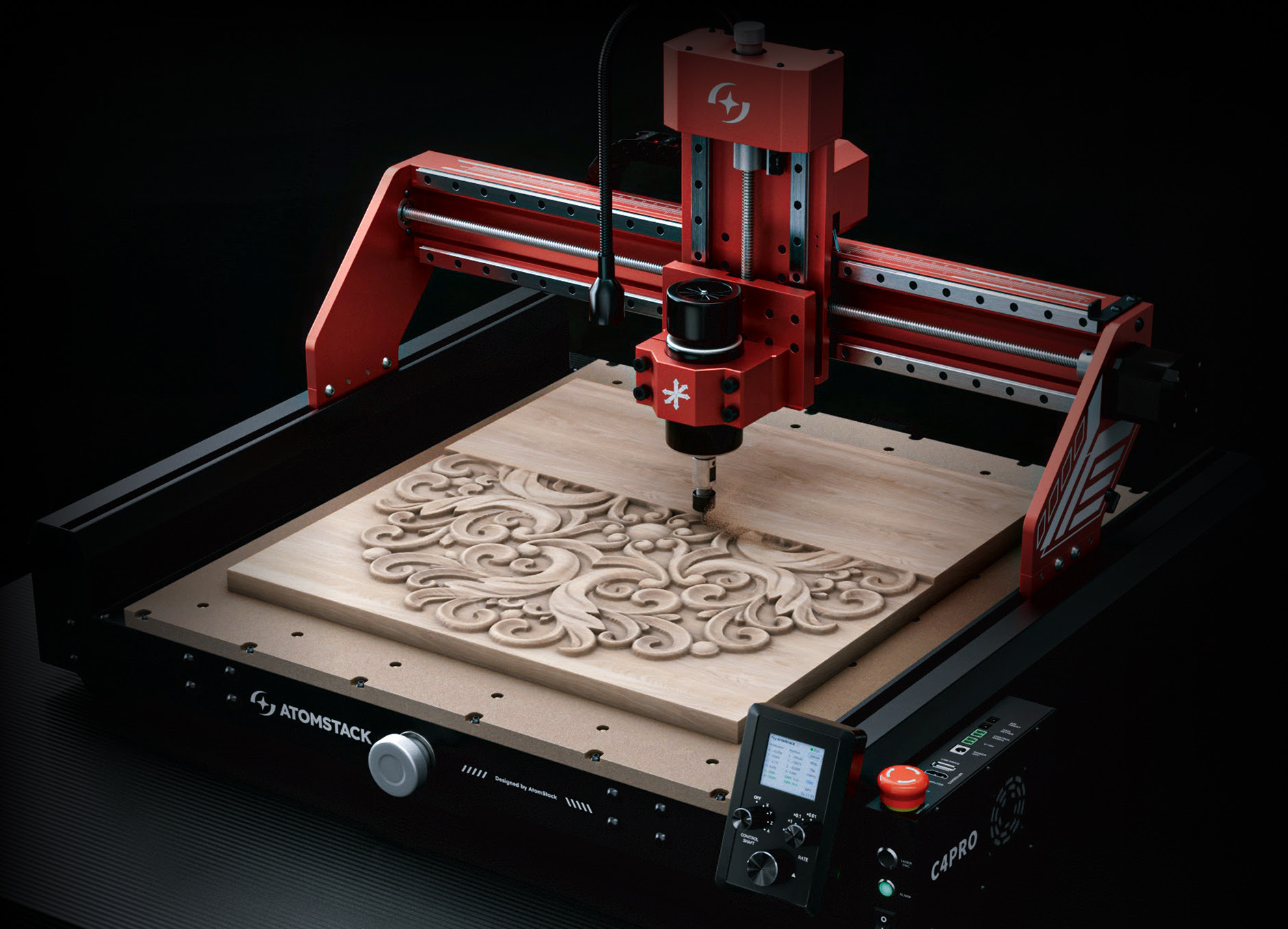 AtomStack C4 CNC router seen at an angle. A piece of wood is being milled revealing an intricate pattern of swirls.