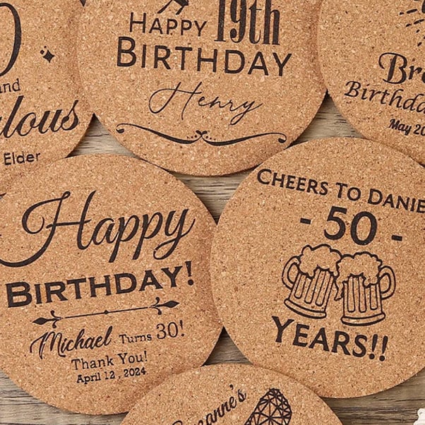 Several cork coasters with diffferent engraved designs of birthday wishes