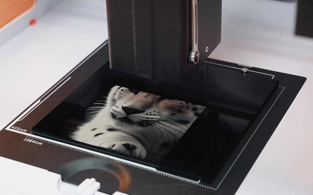 Close-up of the AtomStack P1 IR module engraving a piece of black opaque acrylic