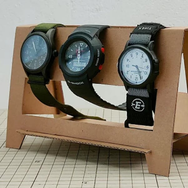 Cardboard stand which holds three wristwatches.