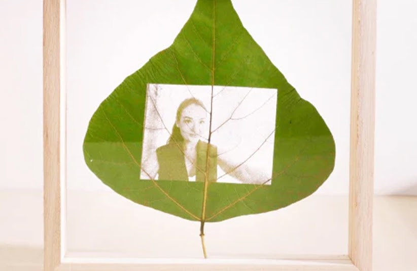 Engraved leaf with a picture of a woman in a transparent frame.