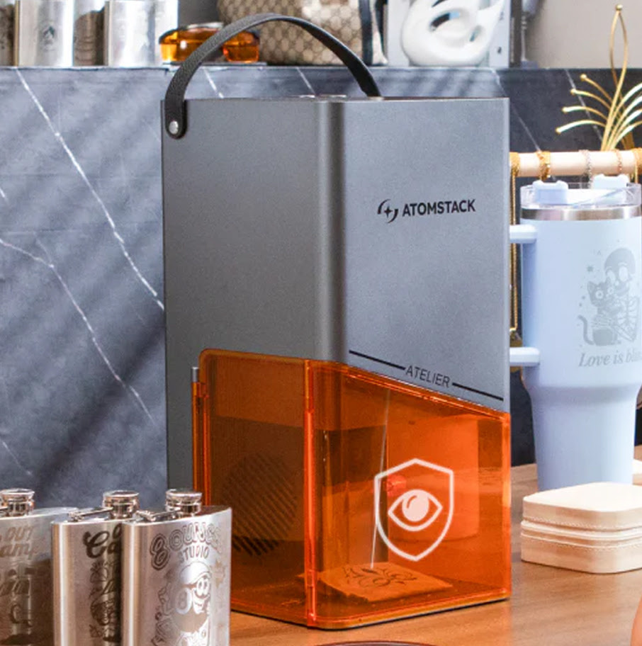 AtomStack Atelier standing on a wooden table. The door is closed.