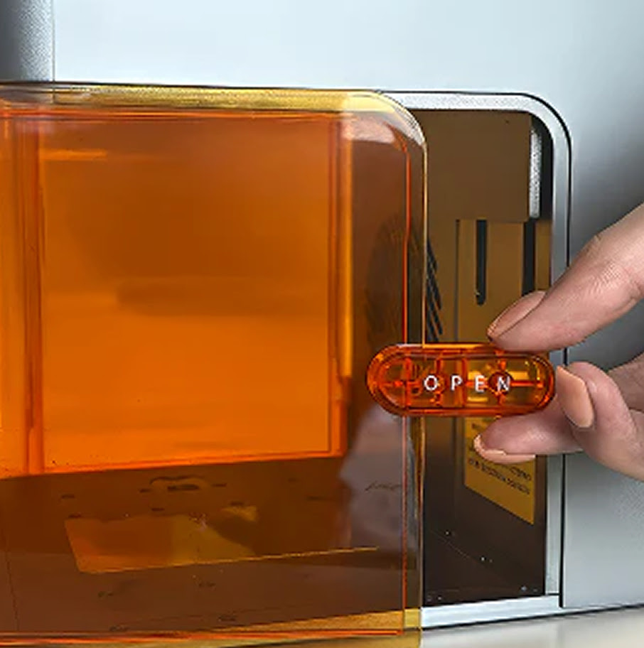 Close-up of a hand opening the door of the AtomStack Atelier.