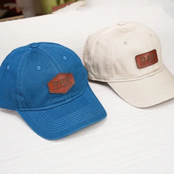 Engraved leather patches on a blule and white cap.