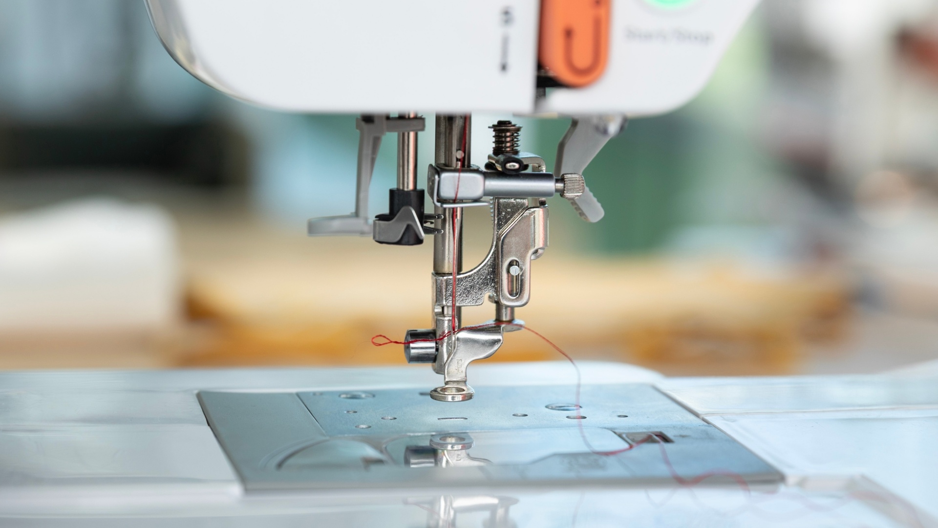 Release the handle and the threader mechanism should pull the thread through the needle
