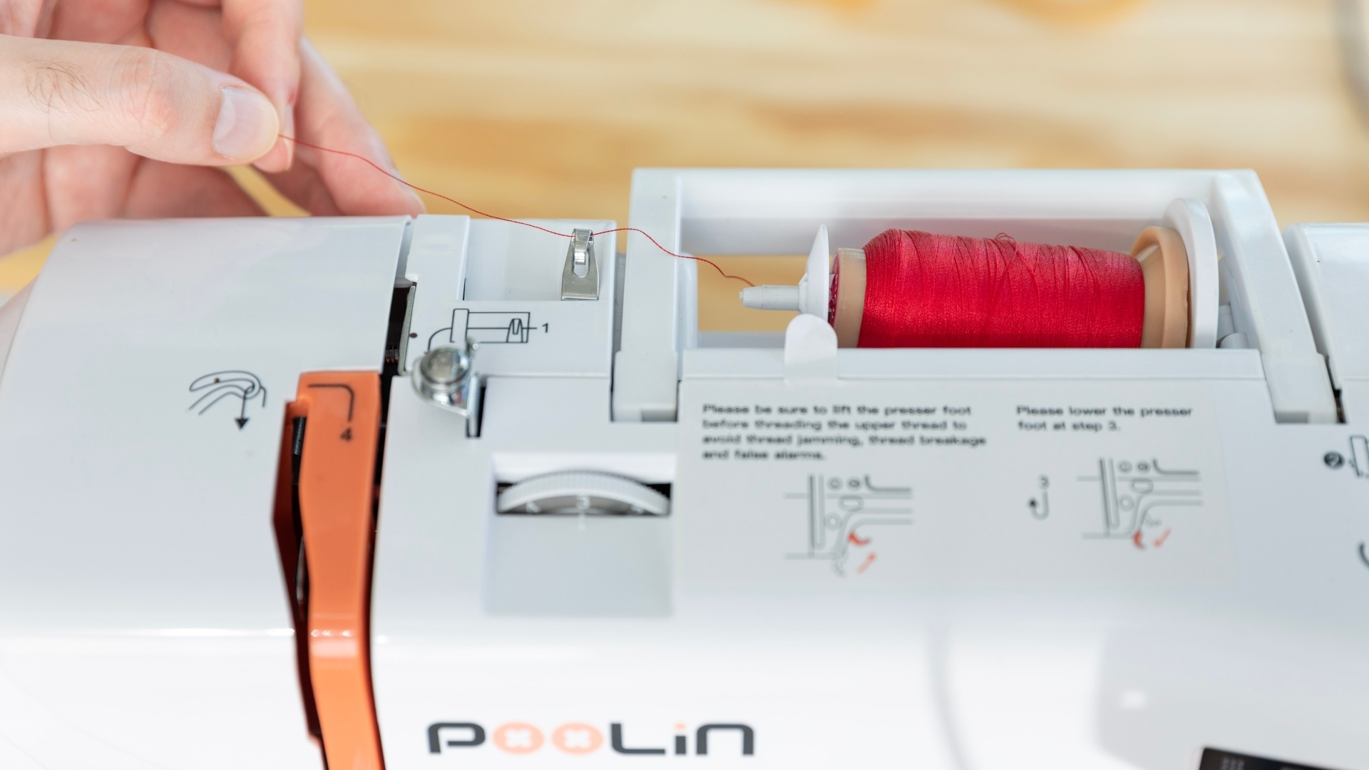 Step 1: pull the thread through the metal loop on top of the machine