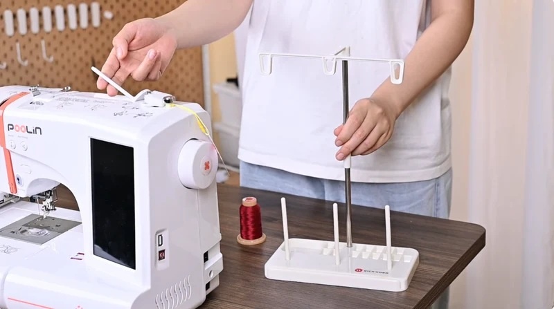You can use a separate spool stand or use the spool holder on top of the embroidery machine